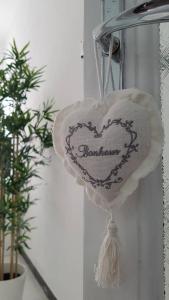 un cœur suspendu sur un mur à côté d'une plante dans l'établissement IL NIDO DELLA ZIA, à La Spezia