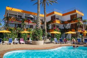 英格兰海滩圣尼古拉斯酒店的酒店楼前有游泳池