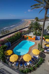 Una vista aérea de una piscina con sombrillas y una playa. en San Nicolás, en Playa del Inglés