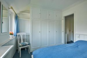 1 dormitorio con 1 cama azul y armario blanco en App. Strandnah, en Rantum