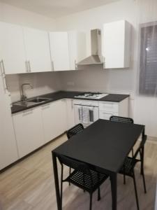 a kitchen with a black table and chairs in it at Casa vacanze Villa Algieri in Schiavonea