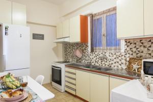una cocina con armarios blancos y una mesa con un bol de fruta en Cozy, Central, Safe Double rooms in apartment, close to Acropolis en Atenas