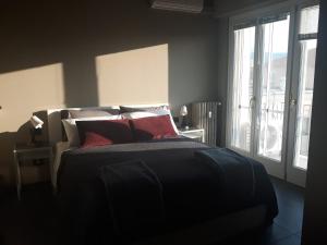 a bedroom with a bed with red pillows and a window at CameLia in Ivrea