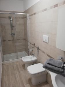 a bathroom with a shower and a toilet and a sink at Casa vacanze Villa Algieri in Schiavonea