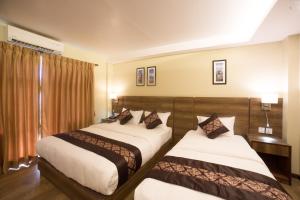 Rúm í herbergi á Ganapati Airport Hotel