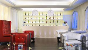 - un bar avec des chaises rouges et des bouteilles de vin dans l'établissement Hotel Meridiana, à Paestum