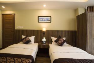 Rúm í herbergi á Ganapati Airport Hotel