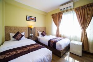 Rúm í herbergi á Ganapati Airport Hotel