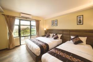 Postel nebo postele na pokoji v ubytování Ganapati Airport Hotel