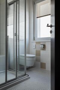 H+ Hotel Ried في ريد إم إنكرايس: حمام مع دش وحوض استحمام ومرحاض