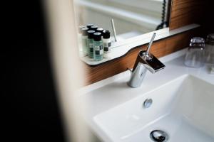 a bathroom sink with a mirror and a faucet at H+ Hotel Ried in Ried im Innkreis