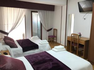 a hotel room with two beds and a desk at Pensión Rama in Carballo +8 photos