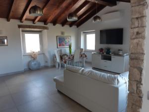 a living room with a white couch and a tv at Casa Isabelle in La Spezia