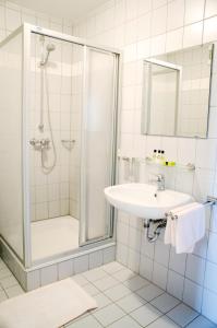 uma casa de banho com um lavatório e um chuveiro em Wallfahrts-Gaststätte Heilbrünnl em Roding