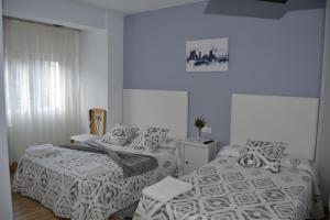 a bedroom with two beds and a window at Pensi&oacute;n Rama in Carballo