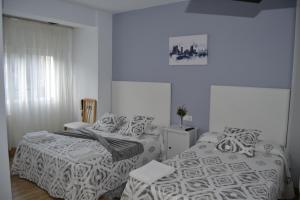 a bedroom with two beds and a window at Pensión Rama in Carballo