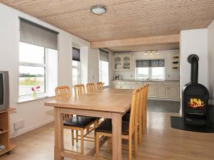uma cozinha e sala de jantar com uma mesa de madeira e uma lareira em 12 person holiday home in Bredebro em Bredebro