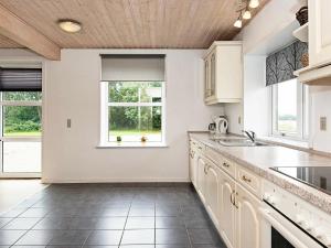 uma cozinha com armários brancos e uma janela em 12 person holiday home in Bredebro em Bredebro