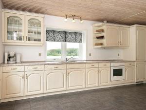 uma cozinha com armários brancos e uma janela em 12 person holiday home in Bredebro em Bredebro