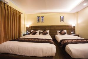 Rúm í herbergi á Ganapati Airport Hotel
