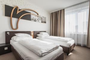 H+ Hotel Ried tesisinde bir odada yatak veya yataklar
