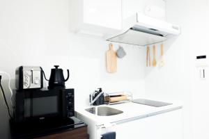 a kitchen with a sink and a microwave at NEST HATAGAYA Stylish Apt in Tokyo