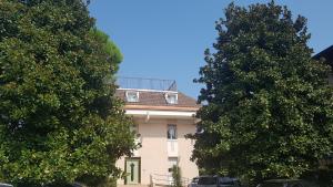a building with two trees in front of it at La Magnolia Apartments Violet in Desenzano del Garda