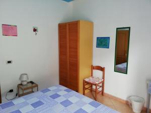 プラーイア・ア・マーレにあるAl Bianco Lotoのベッドルーム1室(ベッド1台、椅子1脚、キャビネット付)