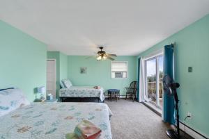 une chambre avec un lit et un ventilateur de plafond dans l'établissement Beach Front On The Bay In Our Rustic Beach Cottage Cottage, à Norfolk