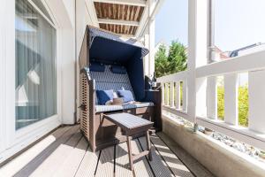 un banc sur un balcon avec une table dans l'établissement Strandhaus Belvedere, à Binz