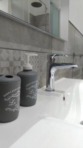 um lavatório de casa de banho com uma torneira e um recipiente de sabão em Sunrise Beach Apartment Trapani em Trapani