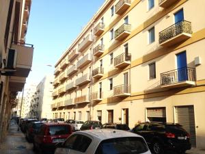 rząd samochodów zaparkowanych przed budynkiem w obiekcie Sunrise Beach Apartment Trapani w Trapani