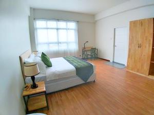 um quarto com uma cama e piso em madeira em Myanandar Residence & Hotel em Yangon