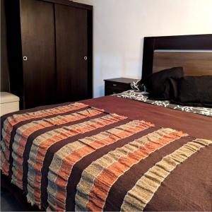 a bedroom with a bed with a striped blanket on it at Loft Once07 in La Rioja