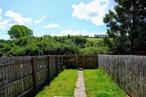 ein Garten mit einem Zaun und einem Feld dahinter in der Unterkunft Perry House, Long Ashton, Bristol by Cliftonvalley Apartments in Bristol