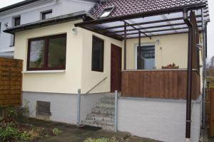 a house with a pergola and stairs in front of it at Ferienwohnung Feldberger Seenlandschaft in Neuhof