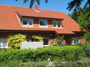 a brick house with an orange roof at Ferienzimmer Alte Kämpe in Heede