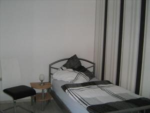 a bedroom with a bed and a chair and a table at Ferienzimmer Alte Kämpe in Heede
