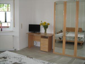 a bedroom with a desk with a computer and a bed at Ferienzimmer Alte Kämpe in Heede