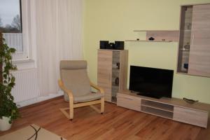 a living room with a chair and a television at Ferienwohnung Feldberger Seenlandschaft in Neuhof