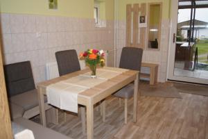 a dining room table with a vase of flowers on it at Ferienwohnung Feldberger Seenlandschaft in Neuhof +4 photos