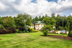 a large house in a yard with a green lawn at Resort Johanka in Kamenice nad Lipou
