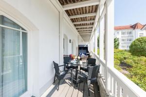 a patio with a table and chairs on a balcony at Strandhaus Belvedere in Binz