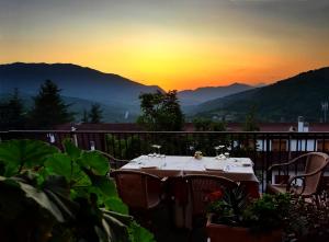 un tavolo su un balcone con il tramonto sullo sfondo di Hotel Cercone a Caramanico Terme