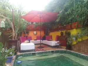 une terrasse avec un parasol et une piscine dans l'établissement Riad Laith, à Marrakech