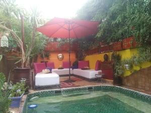 a patio with an umbrella and a pool at Riad Laith in Marrakesh