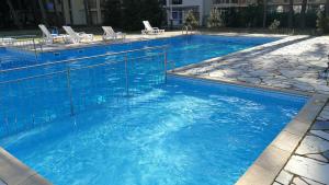 a large swimming pool with blue water and white chairs at De Luxe Blue Mare in Łukęcin