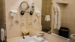 La salle de bains est pourvue d'un lavabo, d'un miroir et d'un téléphone. dans l'établissement JELSOMINOHotel, à Astana