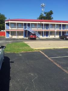 a parking lot in front of a large building at Deluxe Inn Austin in Austin