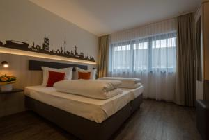 a bedroom with a large bed and a large window at Garni Hotel Schumacher in Filderstadt